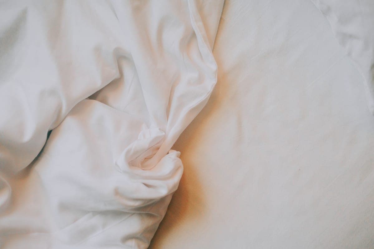 Close-up of crisp white cotton bed sheet fabric